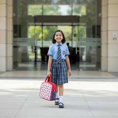 Square lifestyle image of a school girl carrying the Joy Berry Pop red strawberry print lunch bag